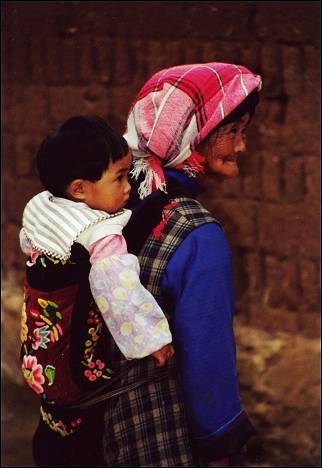 China, Yunnan - Huize, old woman with child on her back