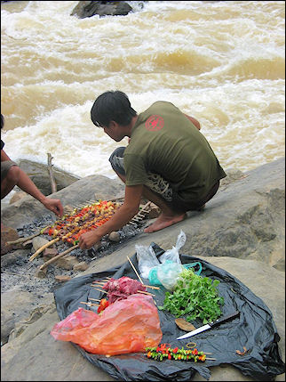Laos - Lunch is prepared on rocks during kayak trip