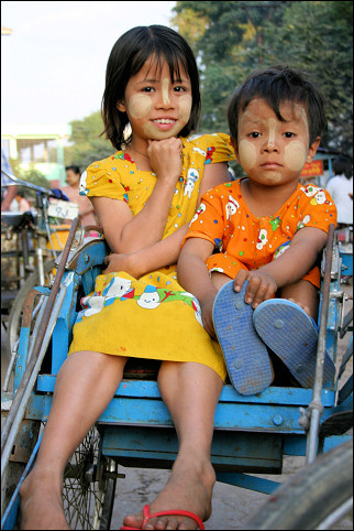 Myanmar, Monywa - Children in riksha with thanaka