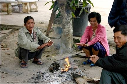 Thailand - Fang, Tha Ton Thai warm their hands over a fire