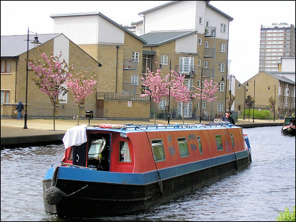 United Kingdom, London - Traditional narrowboat between new buildings